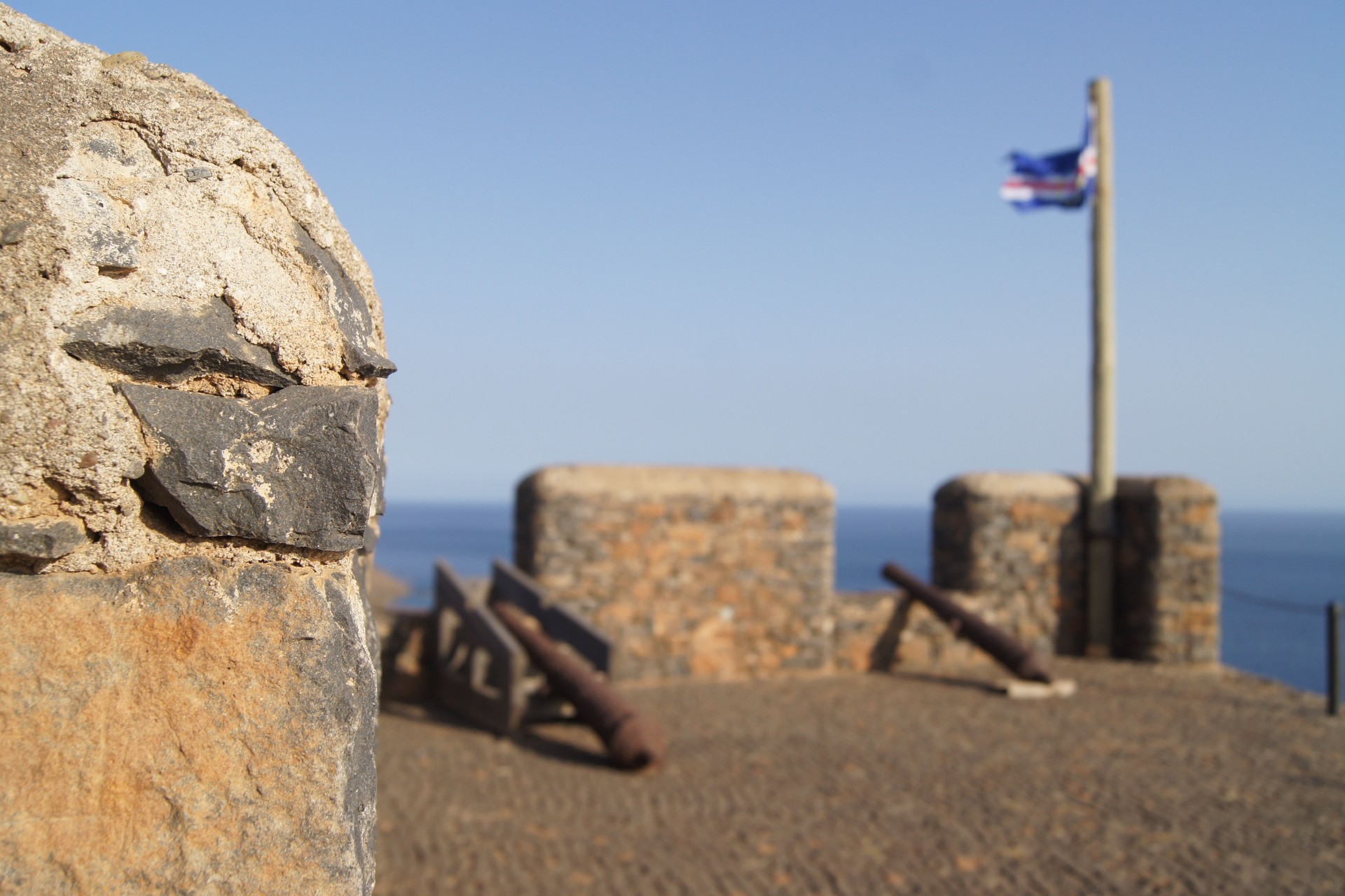 The historic harbor of Cidade Velha on Santiago island, a UNESCO site, with colonial buildings and boats in the bay.