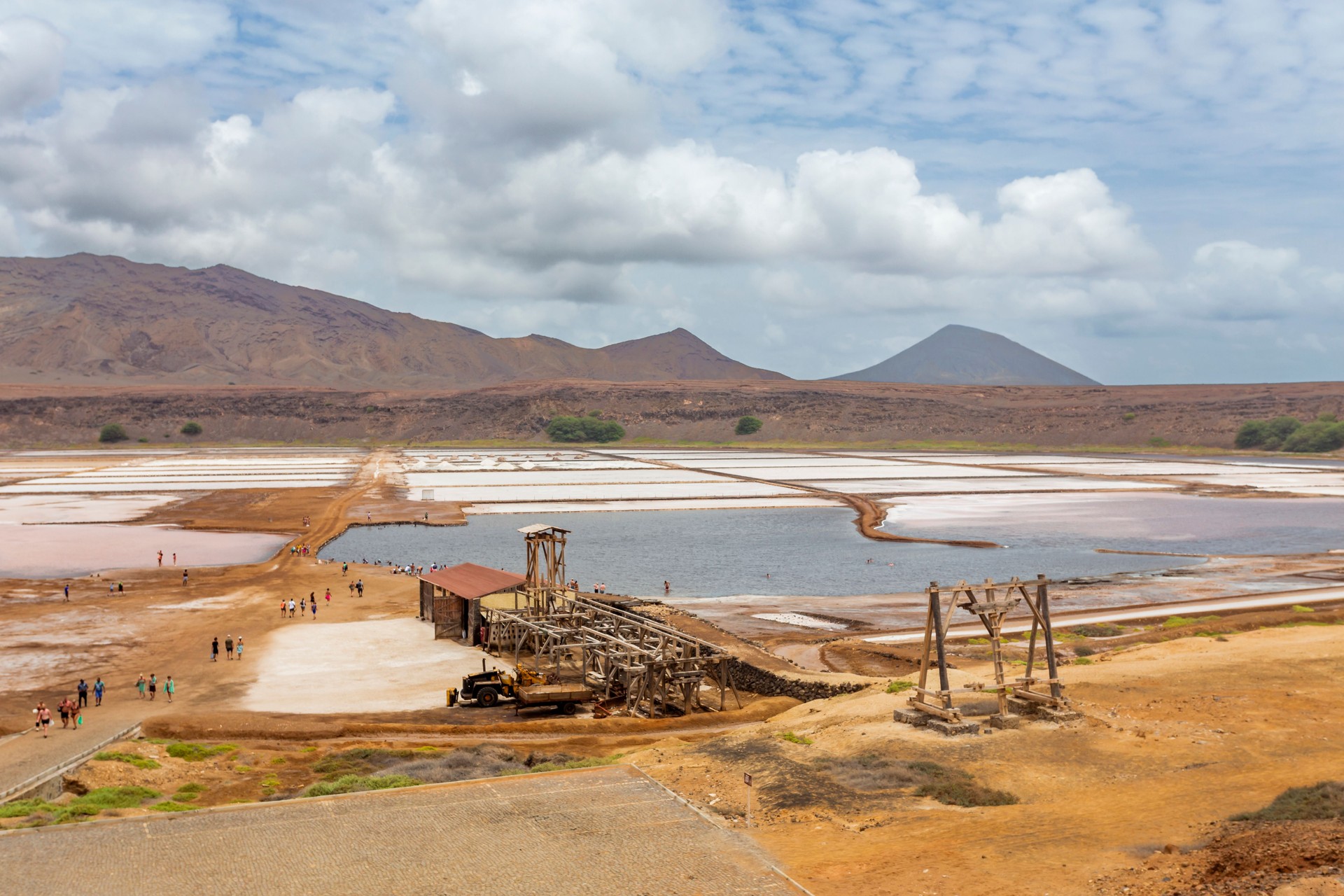 View of the historic salt pans in the Pedra de Lume crater on Sal island, showing the mineral-rich water and old mining structures.