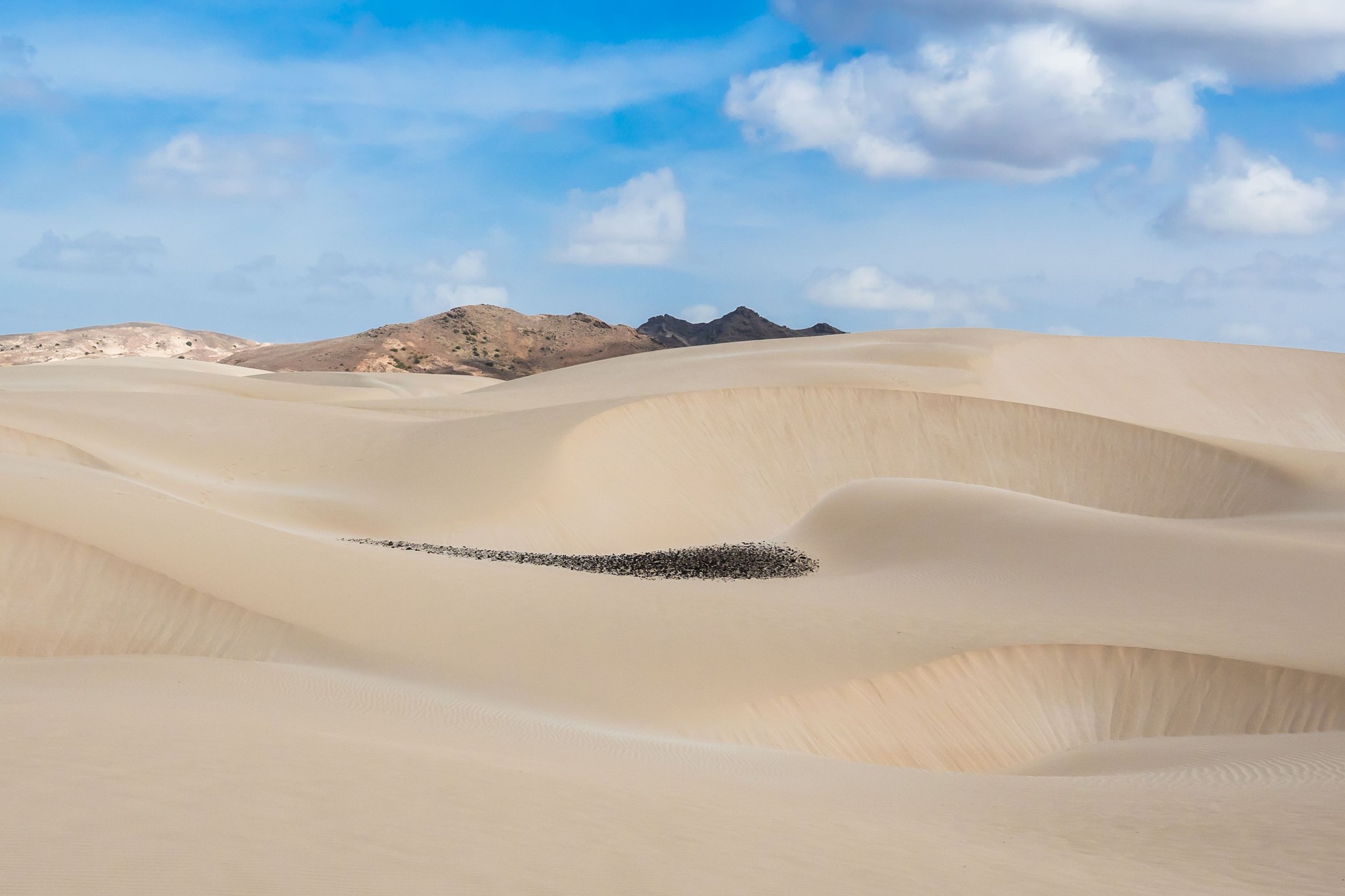 Expansive, rolling white sand dunes of the Viana Desert on Boa Vista island under a clear blue sky.